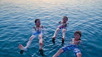 Familie im Toten Meer bei Sonnenuntergang