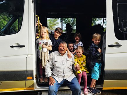 Reiseleiter sitzt mit Kindern im Bus - Garden Route mit Kindern