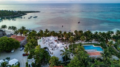 Ein atemberaubender Blick auf das ruhige Wasser mit Booten und einer palmengesäumten Küste in einem tropischen Paradies.