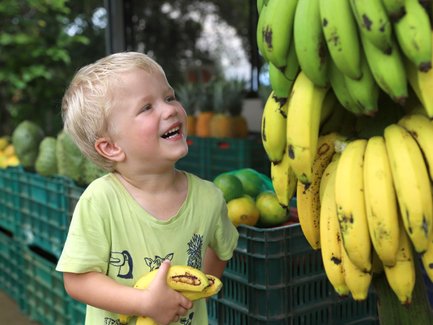 Kleines Kind greift nach Bananen – Costa Rica Familienreise