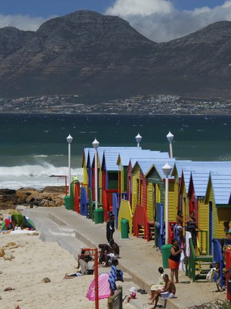 Farbenfrohe Strandhäuschen und badende Familien am St James Beach bei Kapstadt – Garden Route mit Kindern