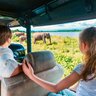 Eine Familie fährt im offenen Jeep durch den Udawalawe Nationalpark auf der Suche nach wilden Tieren – Sri Lanka mit Kindern