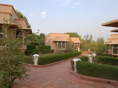Eine malerische Resort-Anlage mit eleganten Bungalows, umgeben von üppigem Grün und gepflegten Gärten.
