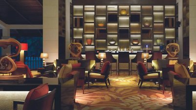 Elegante Bar mit stilvollen Möbeln, sanftem Licht und kunstvollen Dekorationen, die eine entspannte Atmosphäre schaffen.