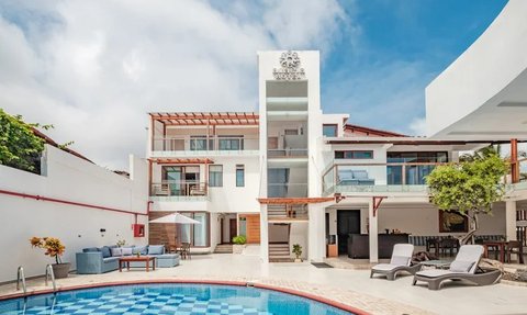 Ein modernes Boutique-Hotel mit einem einladenden Pool und stilvollen Liegen, umgeben von einer hellen, freundlichen Atmosphäre.