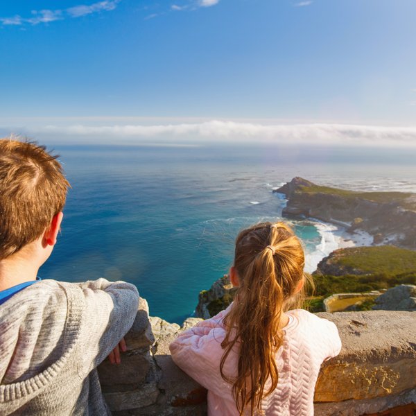 Kinder stehen am Aussichtspunkt des Kaps der Guten Hoffnung und blicken auf das weite Meer – Garden Route Familienreise