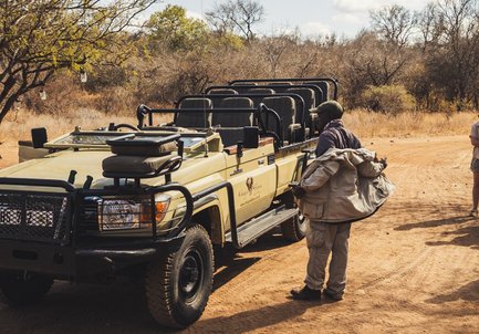 Safari-Guide steht neben Jeep in der Kubu Safari Lodge in Hoedspruit – Südafrika Familienreise