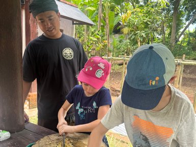 Kinder nehmen an einem traditionellen Kochkurs während eines Dorfbesuchs teil – Bali mit Kindern