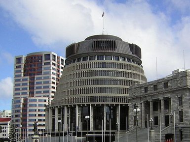 Das moderne Parlamentsgebäude in Wellington, umgeben von Wolkenkratzern und einer klaren blauen Himmel.