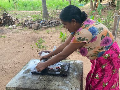 Frau macht in der Nähe von Sigiriya ein traditionelles Gericht – Sri Lanka Familienreise