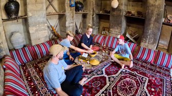 Familie sitzt auf dem Boden im Bait al Safah Museum in Al Hamra – Oman mit Kindern