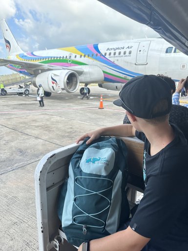 Kind mit Rucksack wartet auf Boarding ins Flugzeug - Thailand mit Kindern