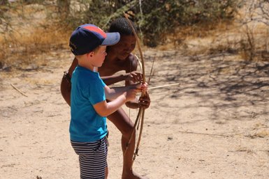 Ein Kind versucht einen Bogen zu spannen - Namibia Urlaub mit Kindern
