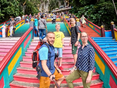 Familie hält den Moment mit einem Selfie auf der farbenfrohen Treppe der Batu-Höhlen fest – Malaysia & Borneo Familienreise