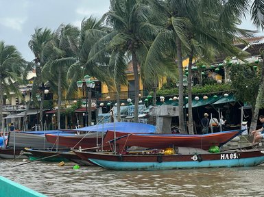 Kleine Boote treiben ruhig auf einem Fluss in Hoi An – Vietnam Familienreise