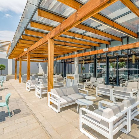 Eine moderne Terrasse mit eleganten weißen Möbeln und Holzverkleidung, ideal für entspannte Treffen im Freien.