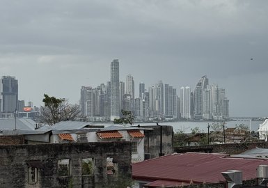 Im Vordergrund stehen historische Gebäude mit roten Dächern, während die moderne Skyline Panamas im Hintergrund sichtbar ist.