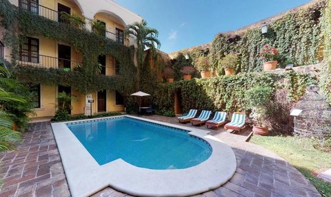 Ein einladender Pool umgeben von üppigem Grün und blühenden Pflanzen, ideal für entspannende Momente im Freien.