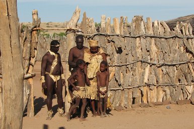 Eine Familie mit zwei Kindern steht vor einem Tor - Namibia mit Jugendlichen