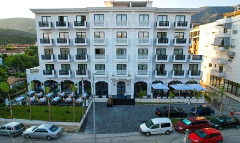 Das elegante Hotel Chimaera mit weißer Fassade und Balkonen bietet eine einladende Atmosphäre in einer malerischen Umgebung.