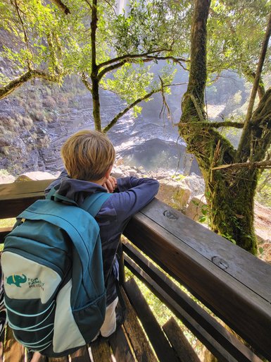 Ein Kind steht am Aussichtspunkt und blickt über die weite Landschaft der Panorama Route – Südafrika Reise mit Kindern