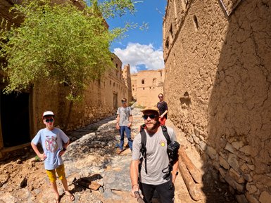 Familie beim Spaziergang durch das Dorf Al Hamra im Oman – Oman Reise mit Kindern