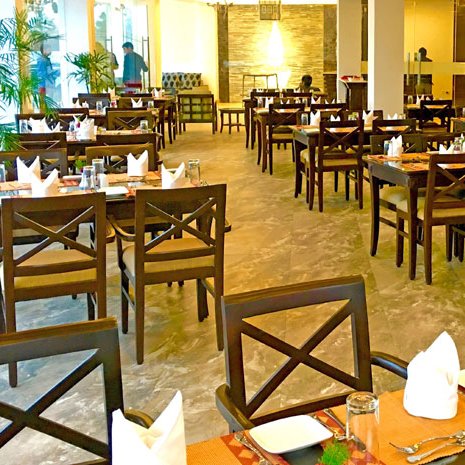 Ein elegantes Restaurant mit Holztischen und Stühlen, das eine ruhige Atmosphäre für Gäste bietet.