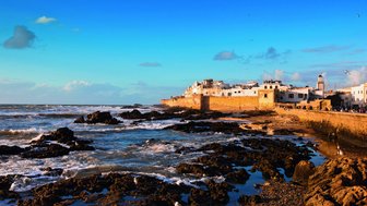 Felsen vor der Küste von Essaouira mit der Altstadt im Hintergrund – Marokko Familienreise