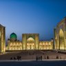 Die beeindruckende Architektur der Registan in Samarkand erstrahlt in warmem Licht, während Menschen die Szenerie genießen.