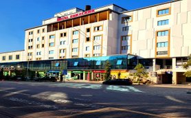 Das moderne Hotel Enkelana in Pogradec zeigt eine helle Fassade mit großen Fenstern und einem einladenden Eingangsbereich.