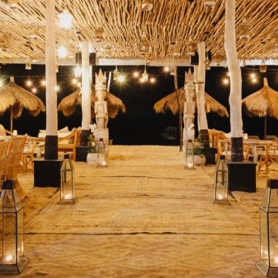 Ein stilvolles Restaurant mit Strohdächern, sanfter Beleuchtung und gemütlichen Sitzbereichen, ideal für Familienessen.