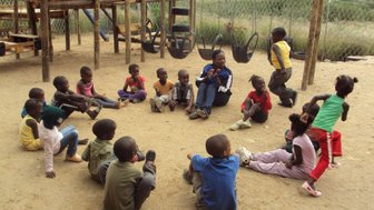 Einheimische Kinder sitzen auf dem Boden - Namibia mit Jugendlichen