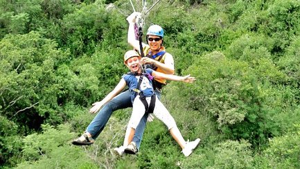 Fröhliches Kind beim Ziplining über Baumwipfel in einem Abenteuerpark in Südafrika – Südafrika Reise mit Kindern