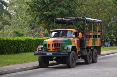 Ein farbenfroher Geländewagen steht auf einer Straße, umgeben von üppigem Grün und Bäumen im Nationalpark Guanayara.