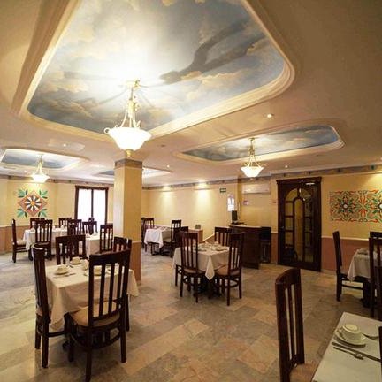 Der Speisesaal ist elegant gestaltet, mit Tischen und Stühlen, die auf einem hellen Boden angeordnet sind.