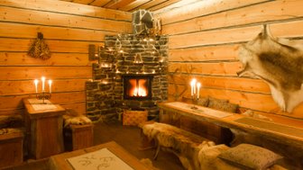Ein gemütlicher Raum mit Holzvertäfelung, einem Kamin und Kerzenlicht schafft eine einladende Atmosphäre.