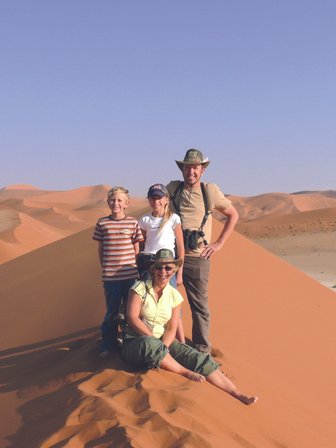 Eine Familie steht auf einer Sanddüne - Namibia mit Kindern
