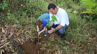 Vater und Kind beim gemeinsamen Baumpflanzen in La Tigra – Costa Rica Reise mit Kindern