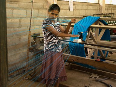 Einheimische Frau konzentriert bei der Arbeit am Webstuhl in der Selyn Handweberei – Sri Lanka Familienreise