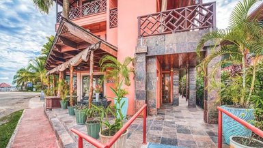 Die Außenansicht des Hotel Palma Royale zeigt eine einladende Fassade mit tropischen Pflanzen und einem barrierefreien Zugang.