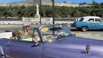 Bunte Oldtimer auf der Straße vor malerischer Kulisse - Kuba mit Kindern