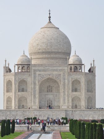 Das majestätische Taj Mahal erhebt sich mit seinen hohen Minaretten und der beeindruckenden Kuppel vor einem klaren Himmel.