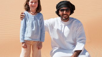 Mädchen trifft einen Beduinen in der Weite der Wahiba Sands – Oman Familienreise