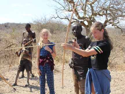 Jugendliche des Hadzabe-Stamms übt Bogenschießen – Tansania mit Kindern