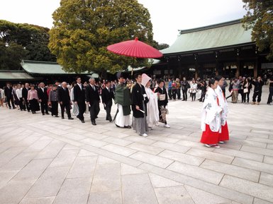 Eine Hochzeitszeremonie im Meiji-Schrein, mit einer festlichen Prozession von Gästen in traditioneller Kleidung.