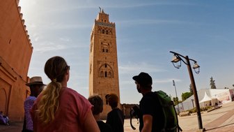 Familie steht vor der Koutoubia-Moschee – Marokko Reise mit Kindern