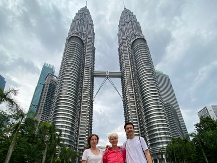 Mutter posiert mit Kindern vor den Petronas Twin Towers in Kuala Lumpur – Malaysia & Borneo Familienreise