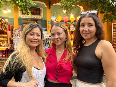 Drei Frauen stehen vor der Altstadt und posieren – Vietnam mit Kindern