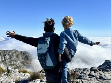 Vater und Kind genießen die Aussicht vom Tafelberg – Südafrika Familienreise