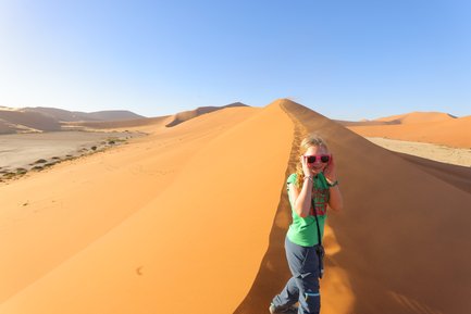 Ein Kind läuft eine Düne hinauf - Namibia Urlaub mit Kindern